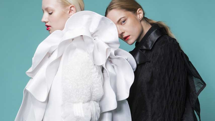 Uma mulher loira e outra ruiva posando como modelo para fotografia para editorial de moda.