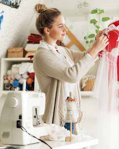 Mulher costurando em máquina de costura doméstica.