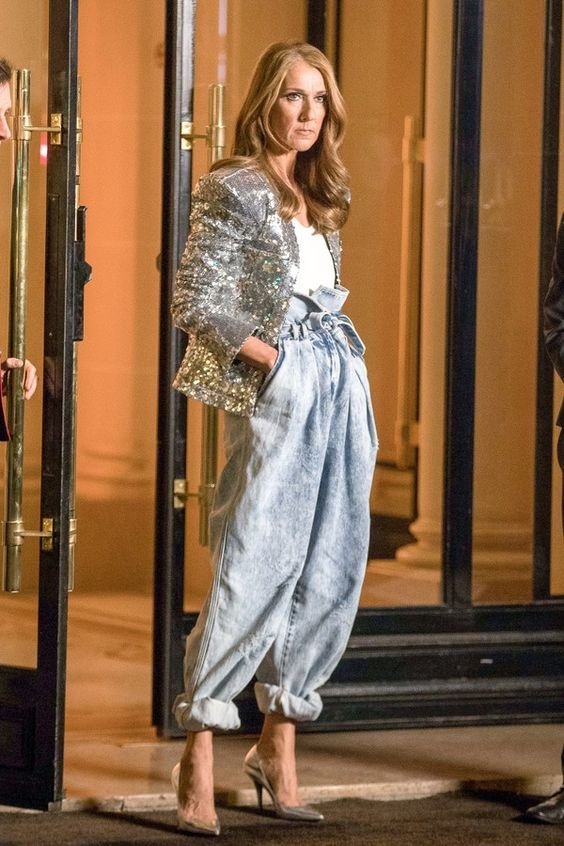 Baggy Jeans Mulher branc, cabelo loiro dourado, com Baggy Jeans com cós alto, blusa branca e terninho prata.