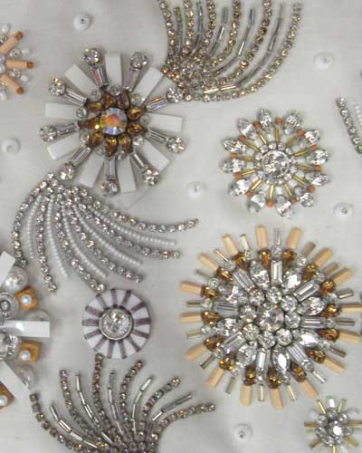 Mulher fazendo bordado em pedrarias em vestido.