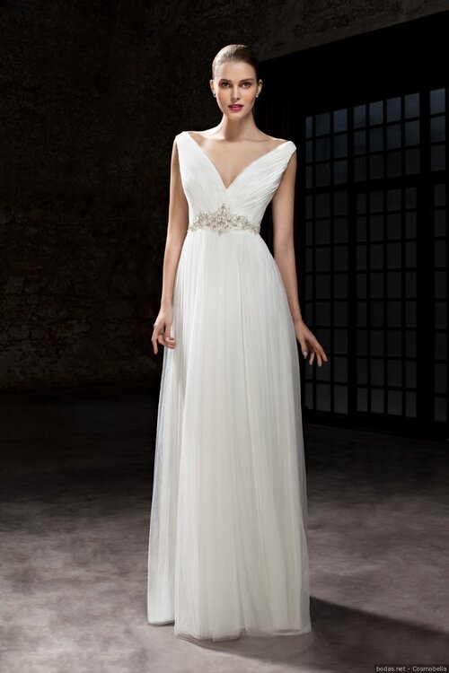 Vestido de noiva franzido de voil de seda, corpo drapeado, decote v, detalhe bordado na cintura em pedraria. Mulher morena com vestido de noiva franzido de voil de seda, corpo drapeado, decote v, detalhe bordado na cintura em pedraria.