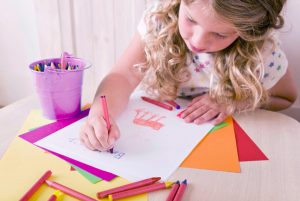 criança costurando em máquina de costura