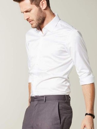 Homem usando casual social. Homem com barba serrada com camisa manga longa branca e calça social acetinada, será uma força durante o verão 2020