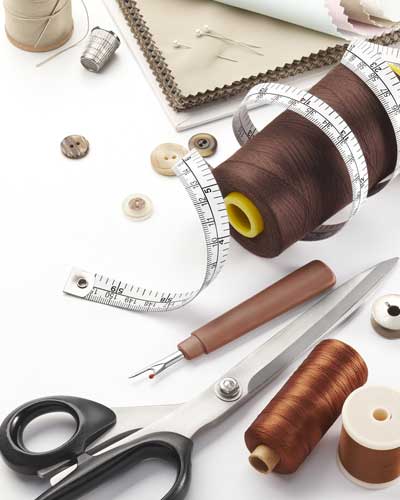 Uma pessoa tirando medida de uma barra de calça para realizar ajustes e reparos